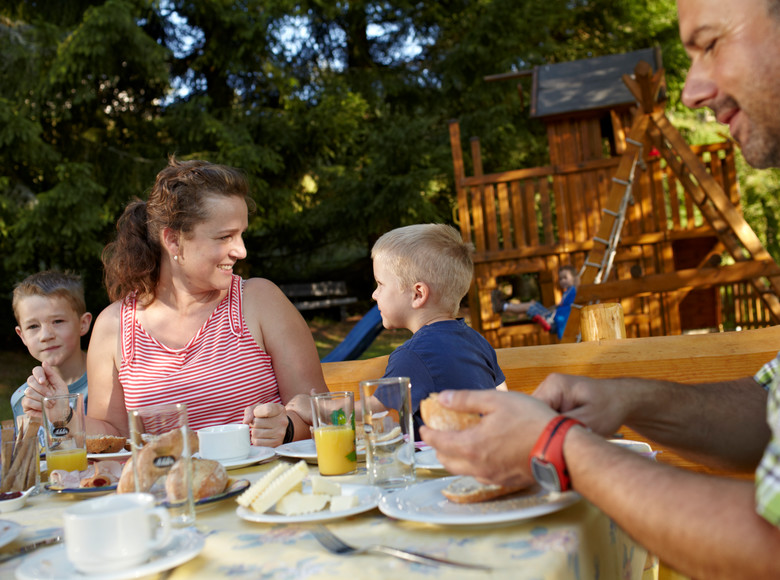 Familie beim gemeinsamen Frühstücken im Freien