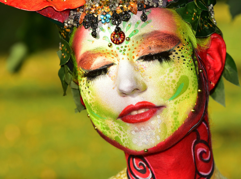 In rot, grün, blau und orange erstrahlt die Kunst der Bodypainting Künstler und Künstlerinnen.