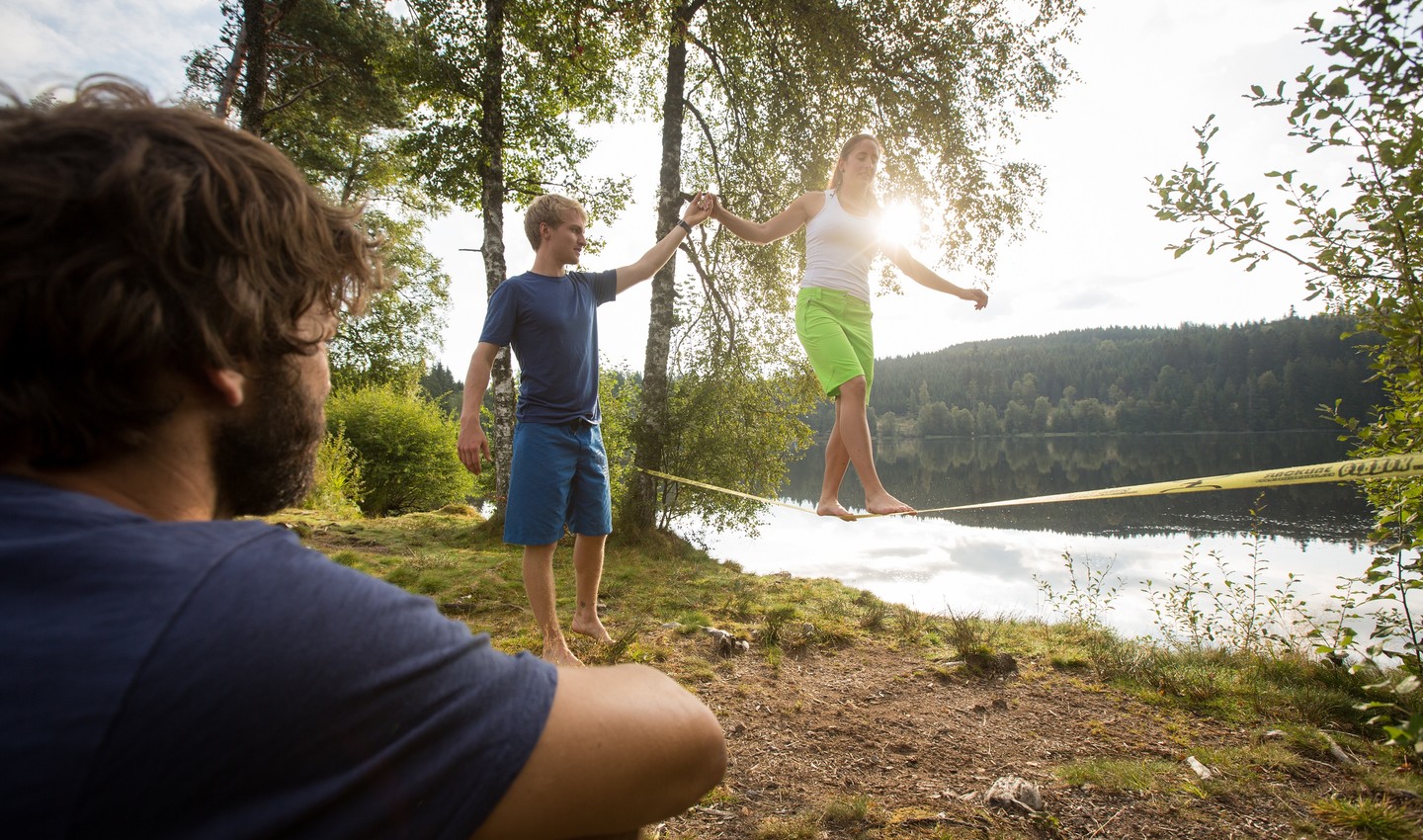 Personen mit einer Slackline am See
