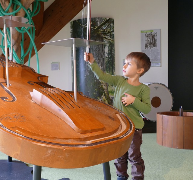 Auf der großen Gitarre lernen Kinder spielerisch Neues.