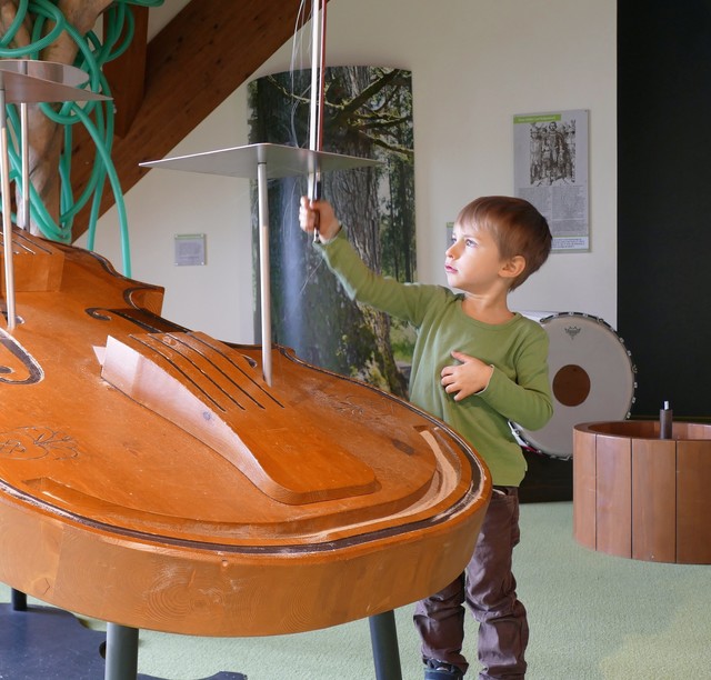 Auf der großen Gitarre lernen Kinder spielerisch Neues.